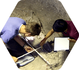 Two students excavating artifacts as part of a biological anthropology trip in Lopburi, Thailand.