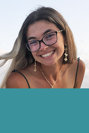 Student in glasses smiling on beach