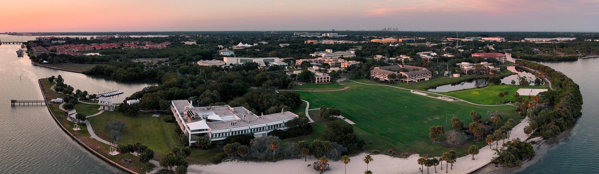 Aerial view of sunset over campus surrounded by water