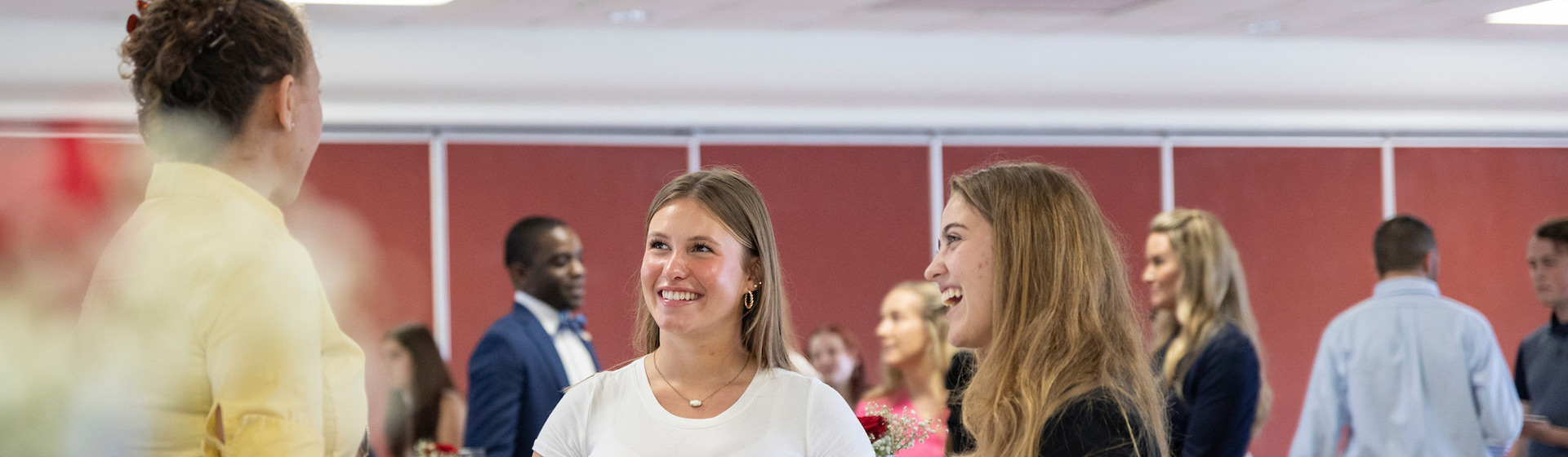Two students talk to a professional at an indoor meeting