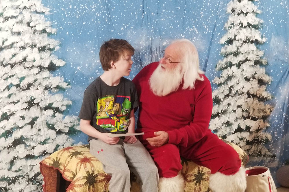 Santa seated next to child