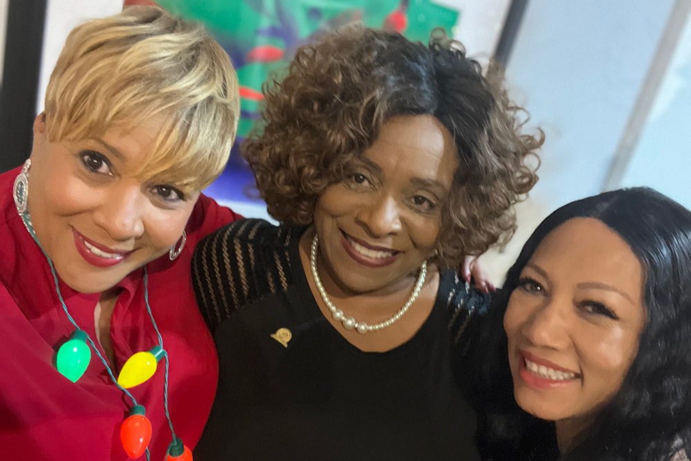 Three ladies standing arm in arm