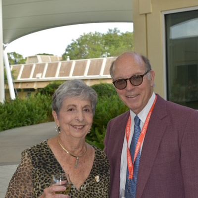 Man in sunglasses and woman holding a drink, side by side