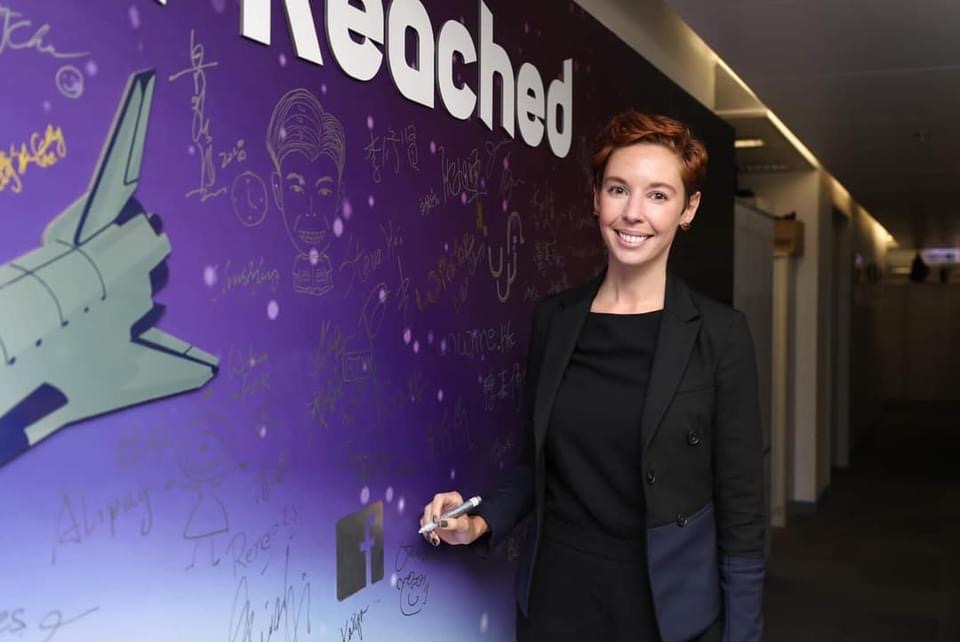 Woman standing in front of a wall with picture of the space shuttle