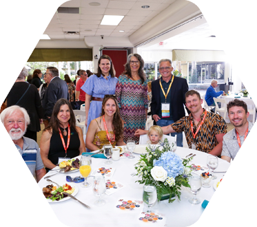 Family seated and standing around a large round table at a gathering