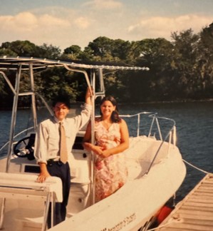 Young couple on a small boat tied to the dock, in formal attire