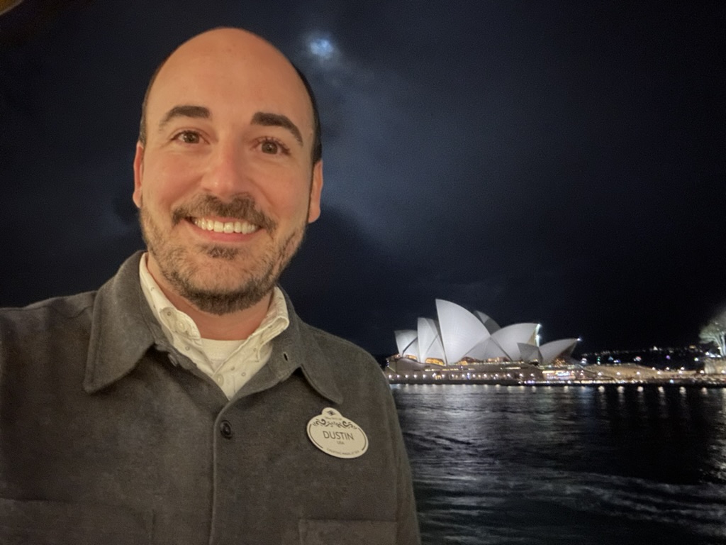 Man smiling in front of Sydney Harbour.