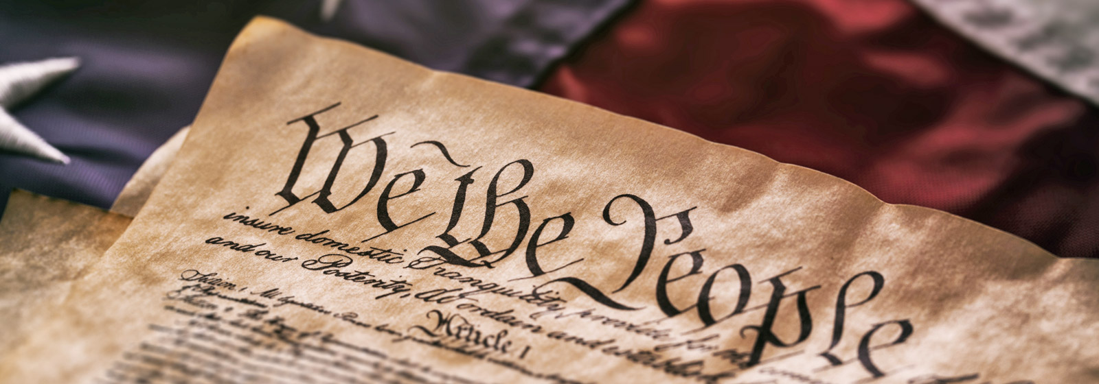 The Constitution sitting atop an old American flag