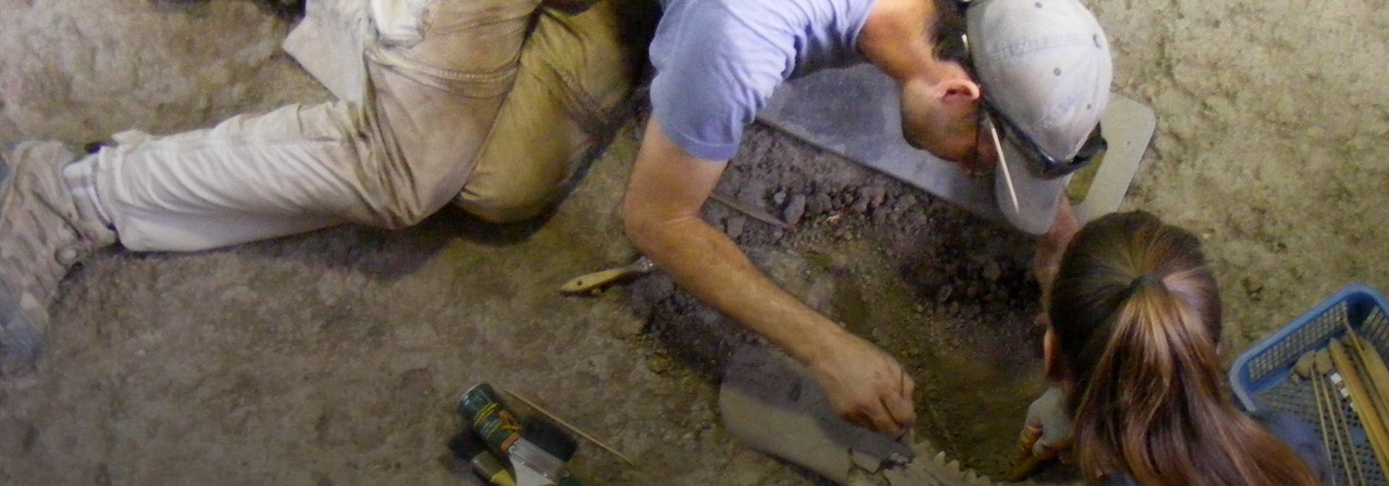 Two students excavating artifacts as part of a biological anthropology trip in Lopburi, Thailand.