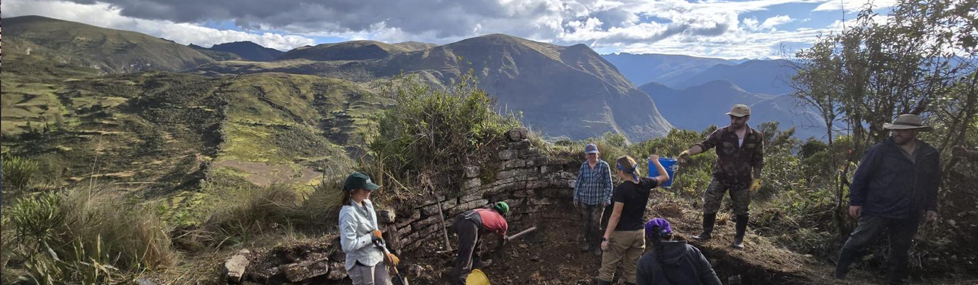 Group of scientists standing near top of a mountain doing excavation