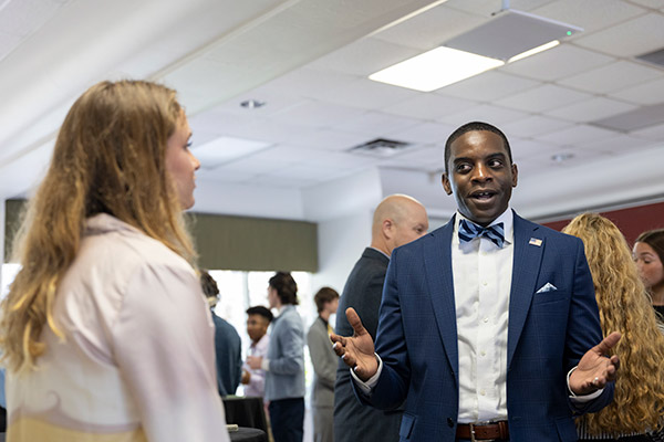 Eckerd student chats with mentor and alumnus in bowtie