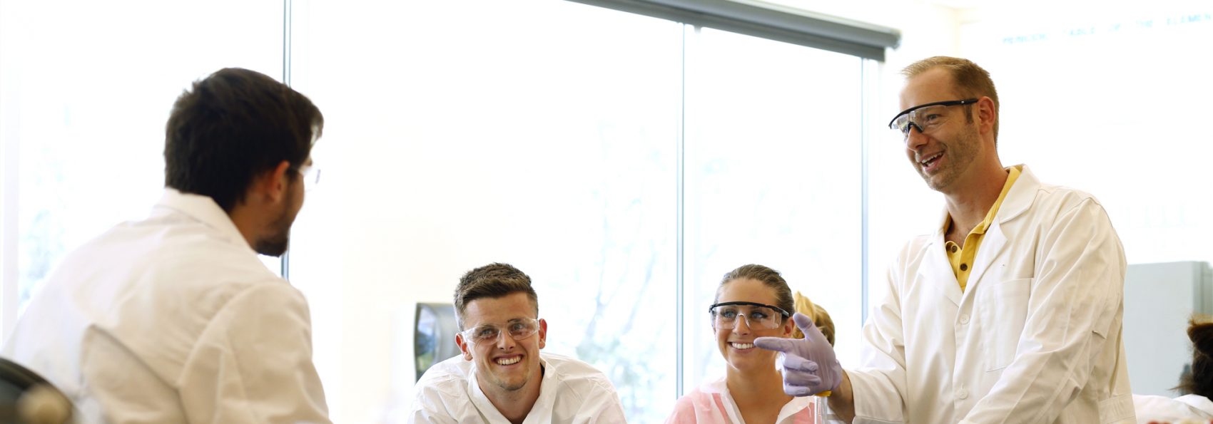 Chemistry students smiling in lab with Professor Joe Larkin