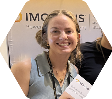 Young woman wearing lanyard holds a brochure that reads IMOTIONS
