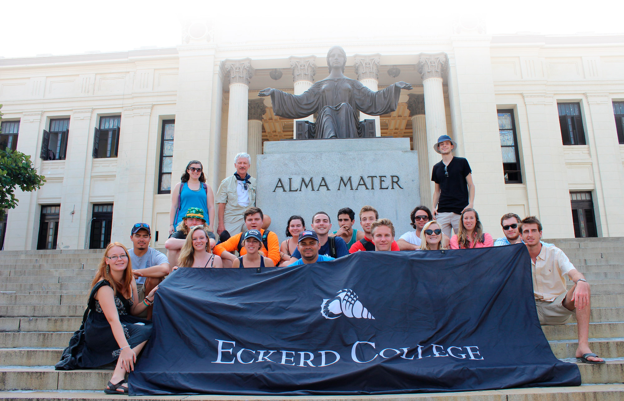 Eckerd students and professor on steps in front of statue in Cuba