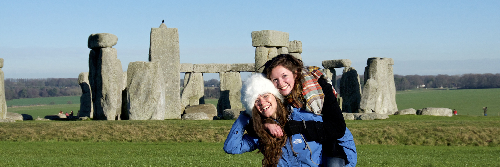Two female students hugging at Stonehenge