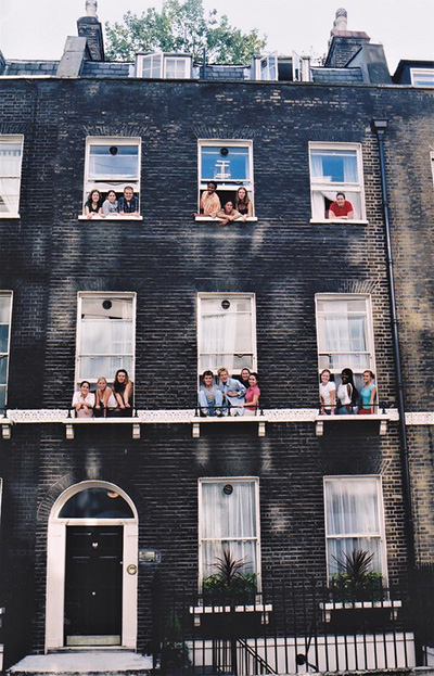 New photo of students sitting in windows of old building