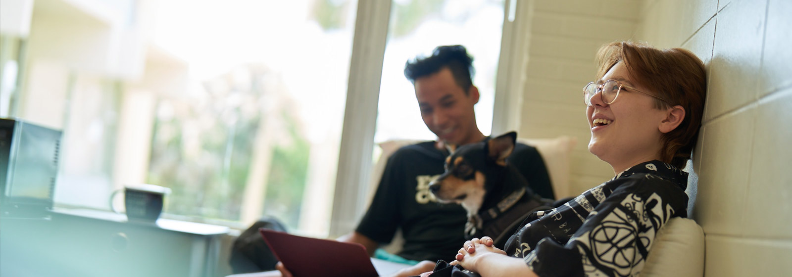 Eckerd students in a dorm room with a dog
