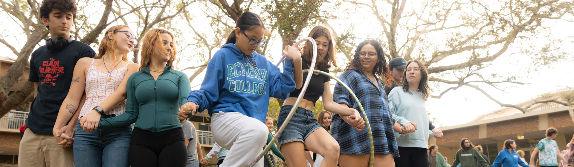Students doing a group activity with hula hoop outdoors