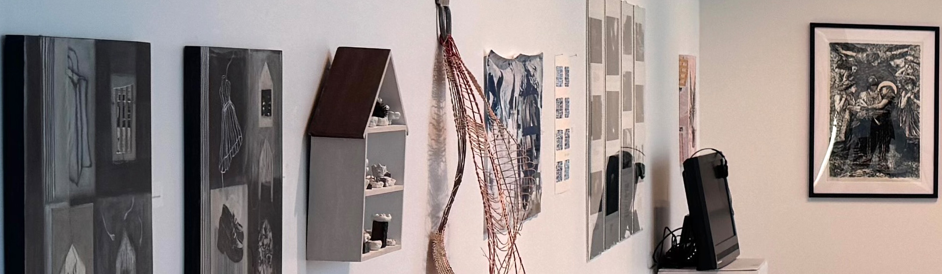 Gallery exhibition showing mixed media art hanging on the wall