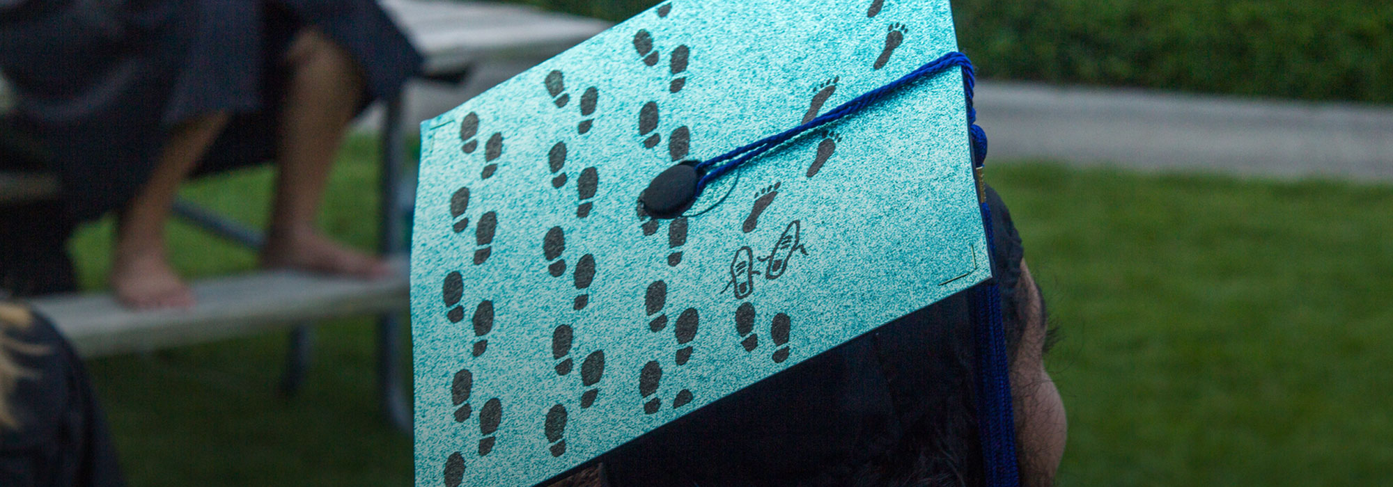 Behavioral Sciences Collegium graduation cap that shows footprints on the sand