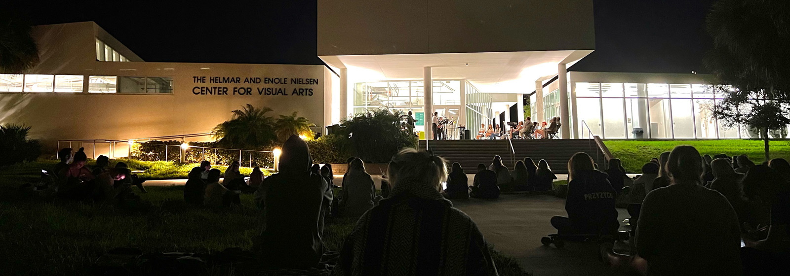 Students play jazz music outdoors at night
