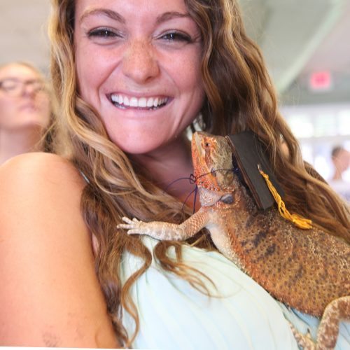 Danielle Becker poses with her pet bearded dragon at pet commencement 2016.
