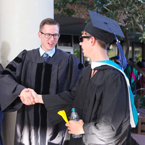 Jon Chopan shakes hands with an Eckerd College graduating senior