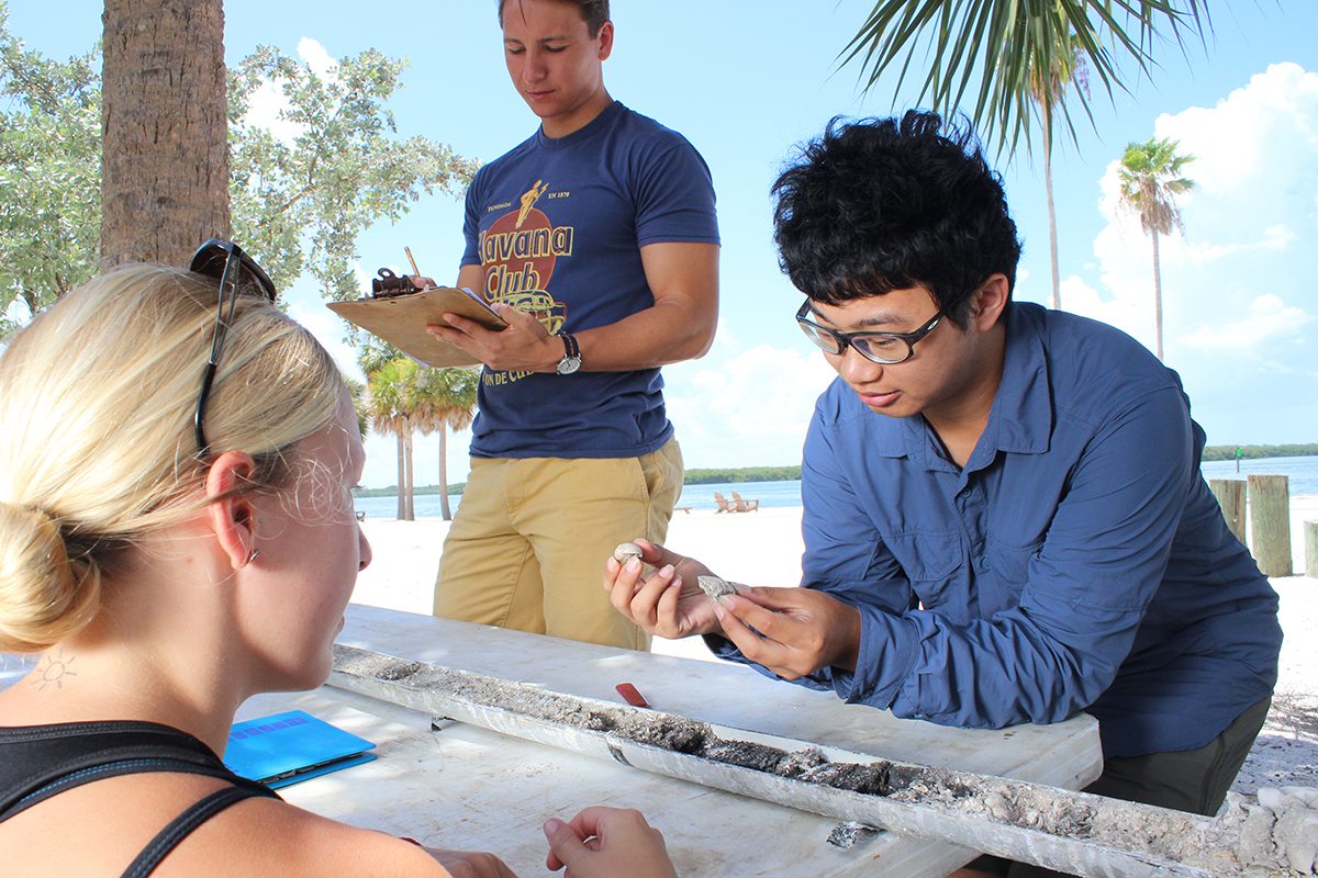 Students looking at a sample while on South Beach