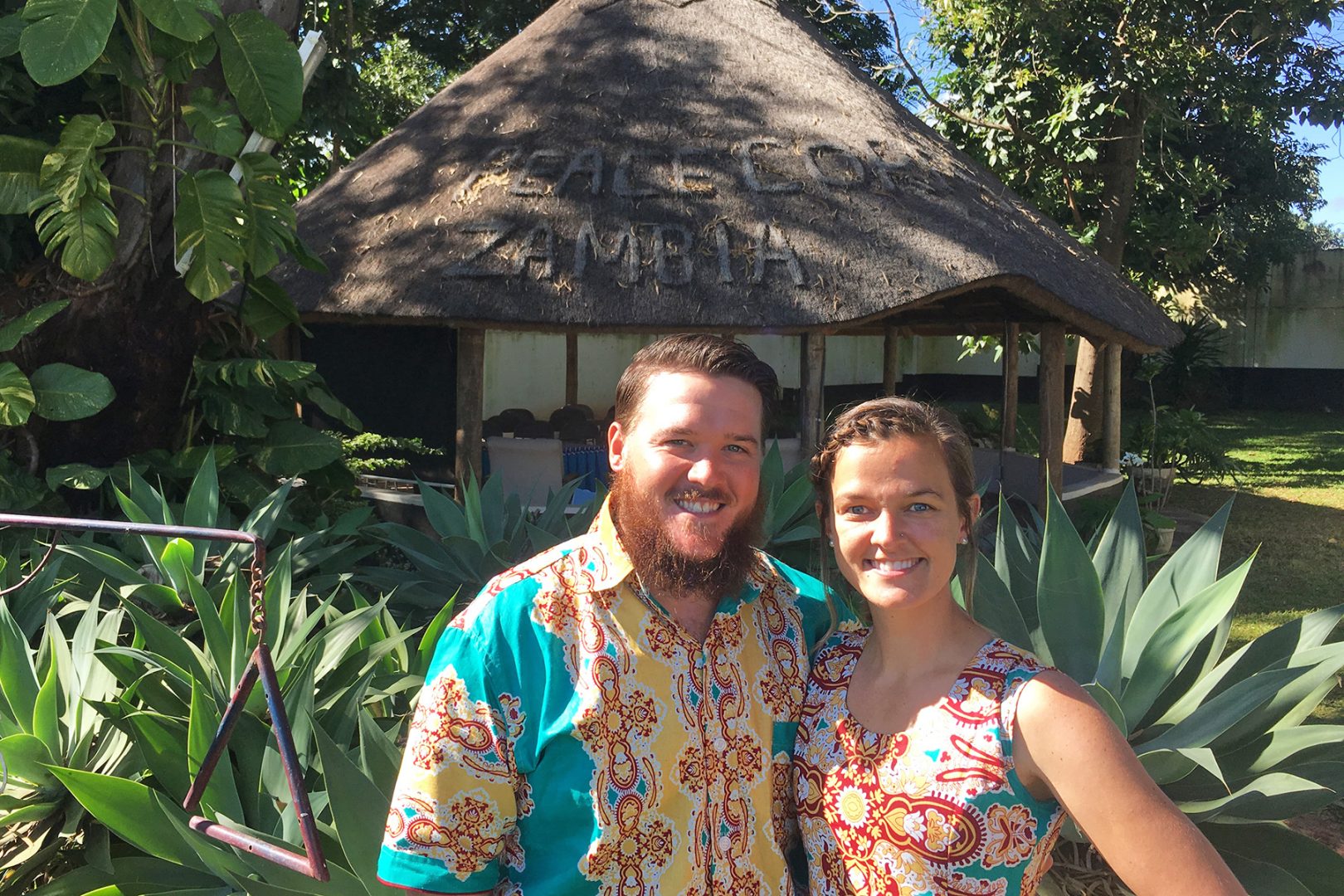 Couple standing in front of hut-like home