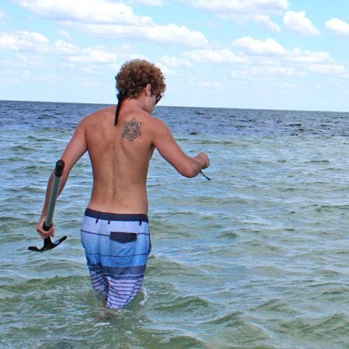 Student in water collecting specimens