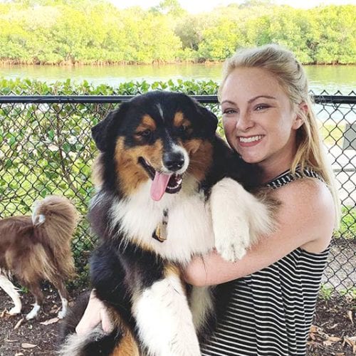 Eckerd College sophomore Presley Carico holding Ezra the dog