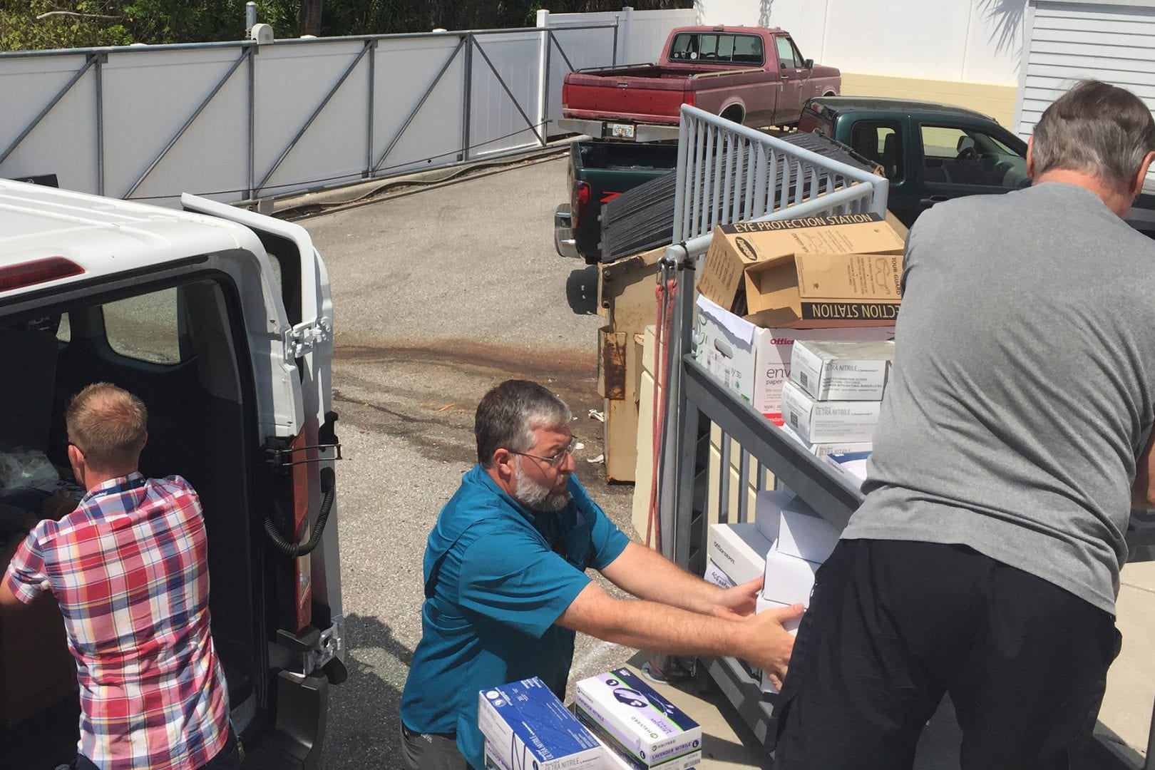 Eckerd College faculty and staff load personal protective equipment into a van