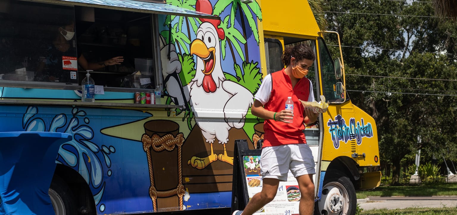 Eckerd student walks away from food truck on campus