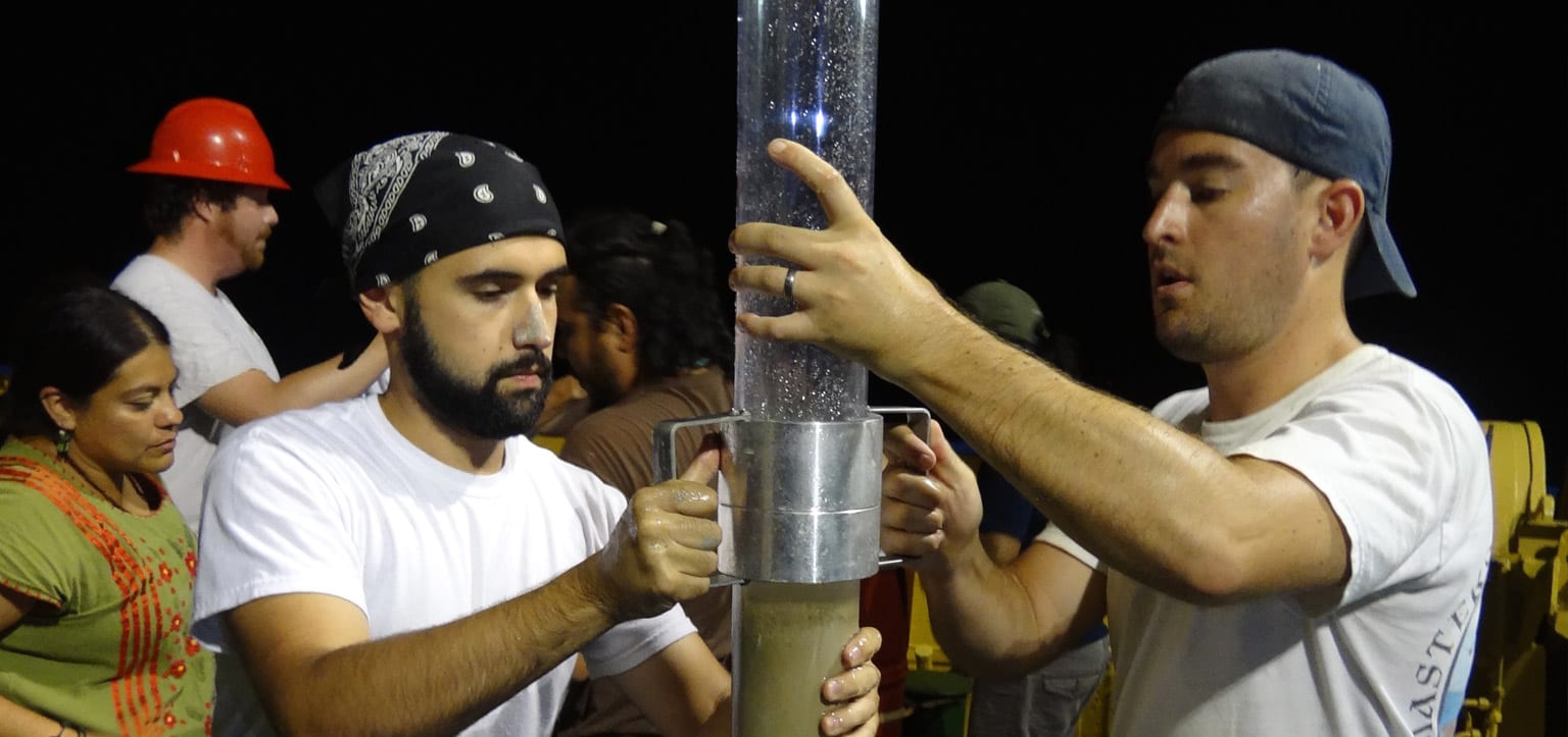 Bryan O'Malley (left) and Patrick Schwing (right) transfer a seafloor sediment core for storage aboard the B/O Justo Sierra, operated by the National Autonomous University of Mexico (photo credit: Devon Firesinger)