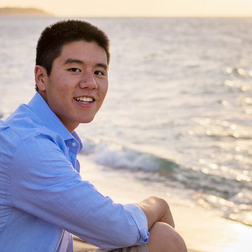 Student seated on the beach