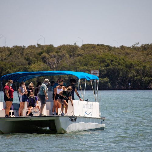 Faculty and students on a boat taking samples from seafloor