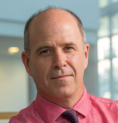 Jim Lang wearing pink shirt and tie