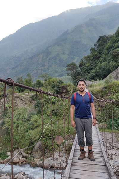 Rupak on a wooden bridge in the mountains