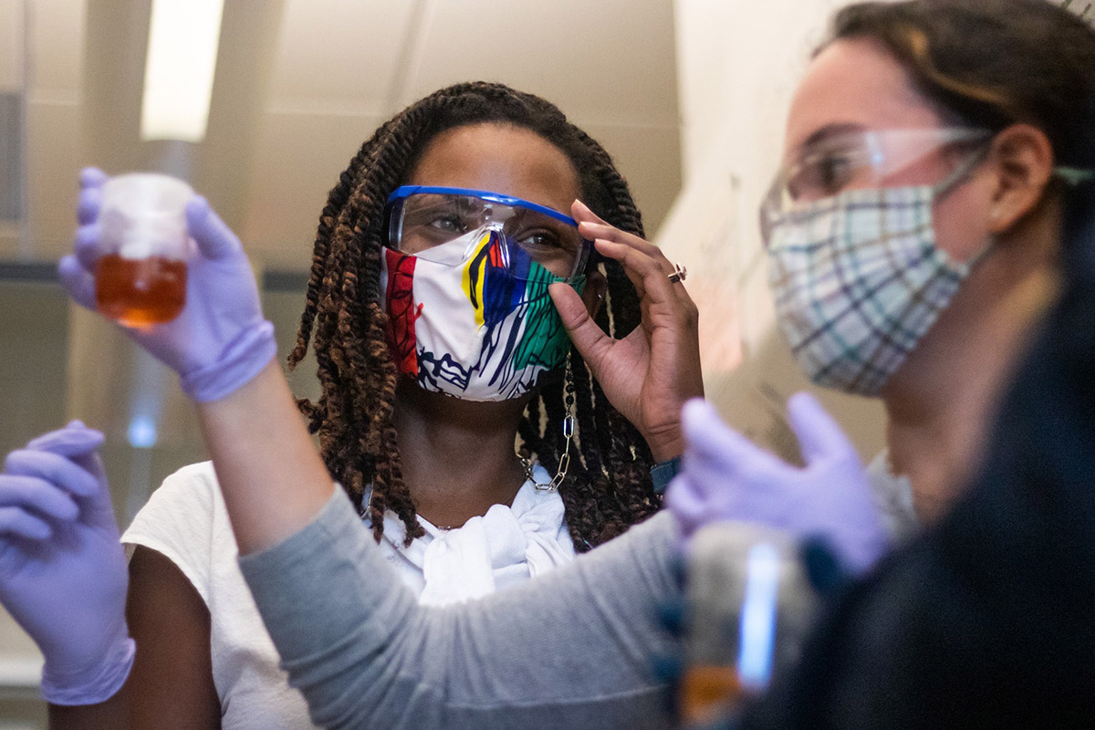 Eckerd chemistry professor Jalisa Ferguson next to student holding beaker