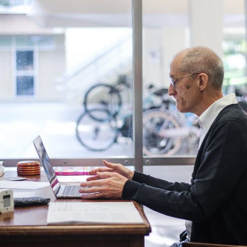 Professor Flaherty at his desk with clock