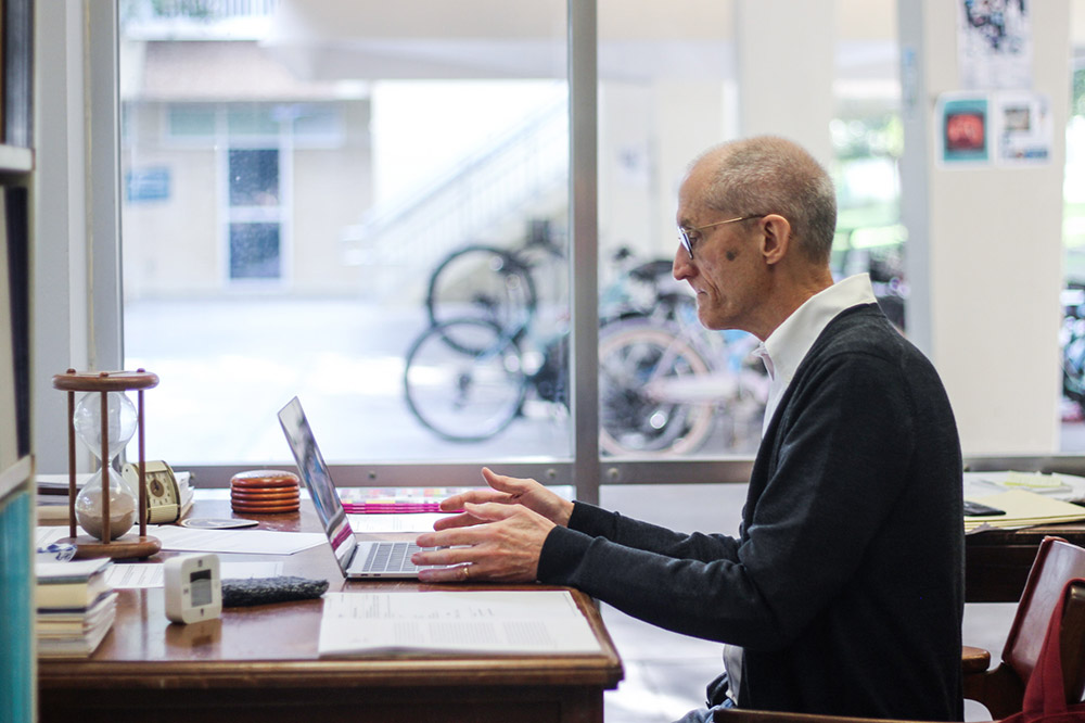 Professor Flaherty at his desk with clock