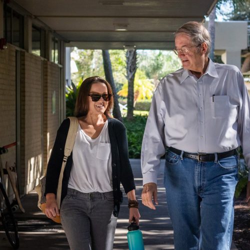 Hutchings walks with Professor Hamilton along sidewalk on campus
