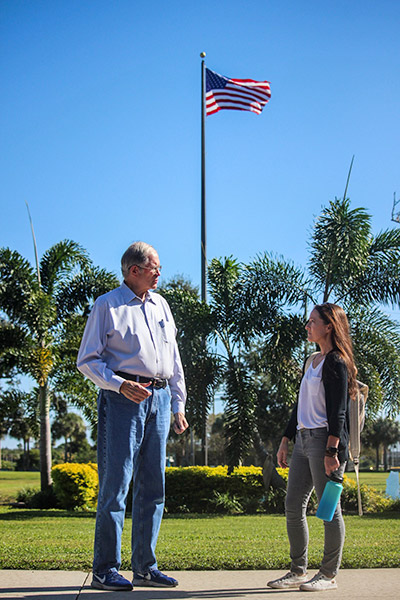 Professor Hamilton with Hutchings in front of U.S. flag