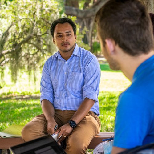 Predoctoral Fellow Rupak Shrestha listening to students outside