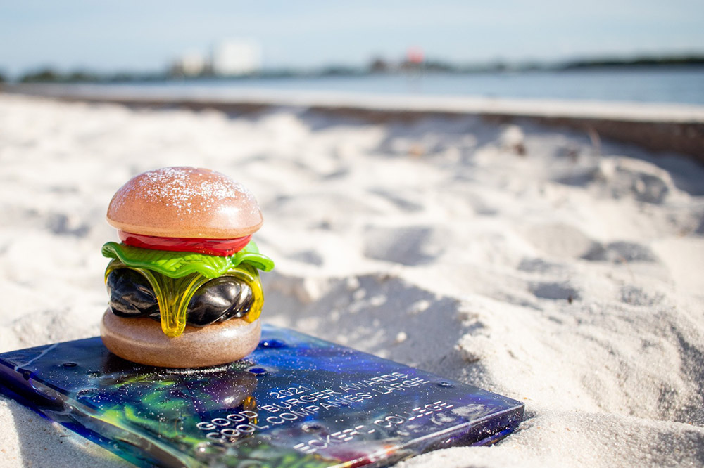 Award in shape of a hamburger sitting on sand on South Beach