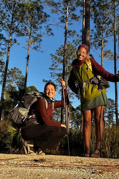 Eckerd college students wearing backpacks and holding walking sticks