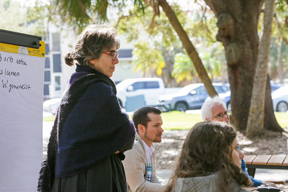 Professor standing outside in discussion with other proessors