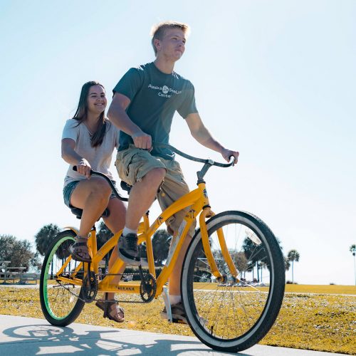 Two student pedaling a tandem bike