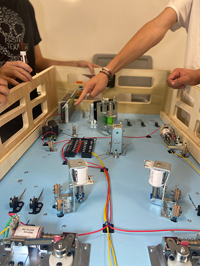 Finger pointing to electronic parts inside pinball machine