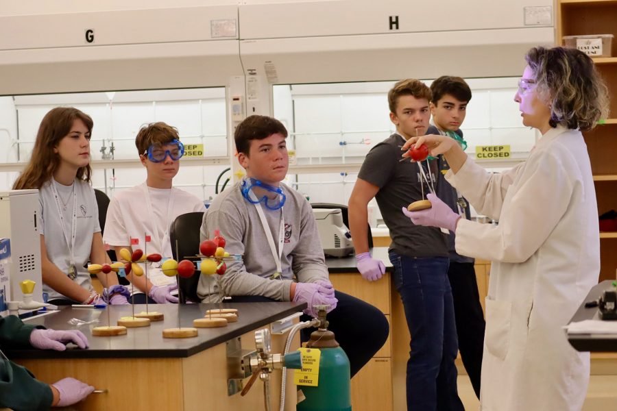 Middle school children watch chemistry professor demonstrate